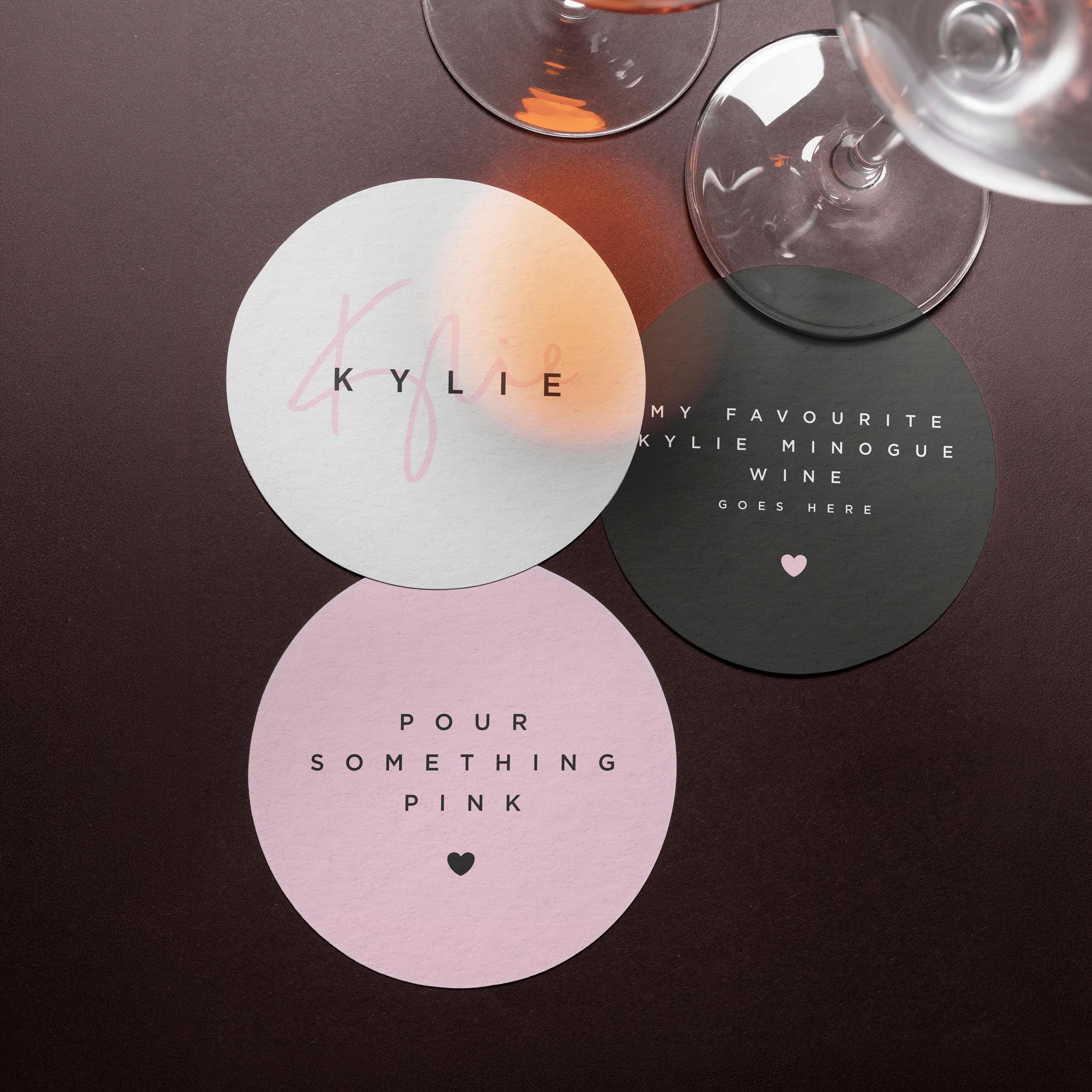drei untersetzer im design der kylie-weine zwischen weingläsern