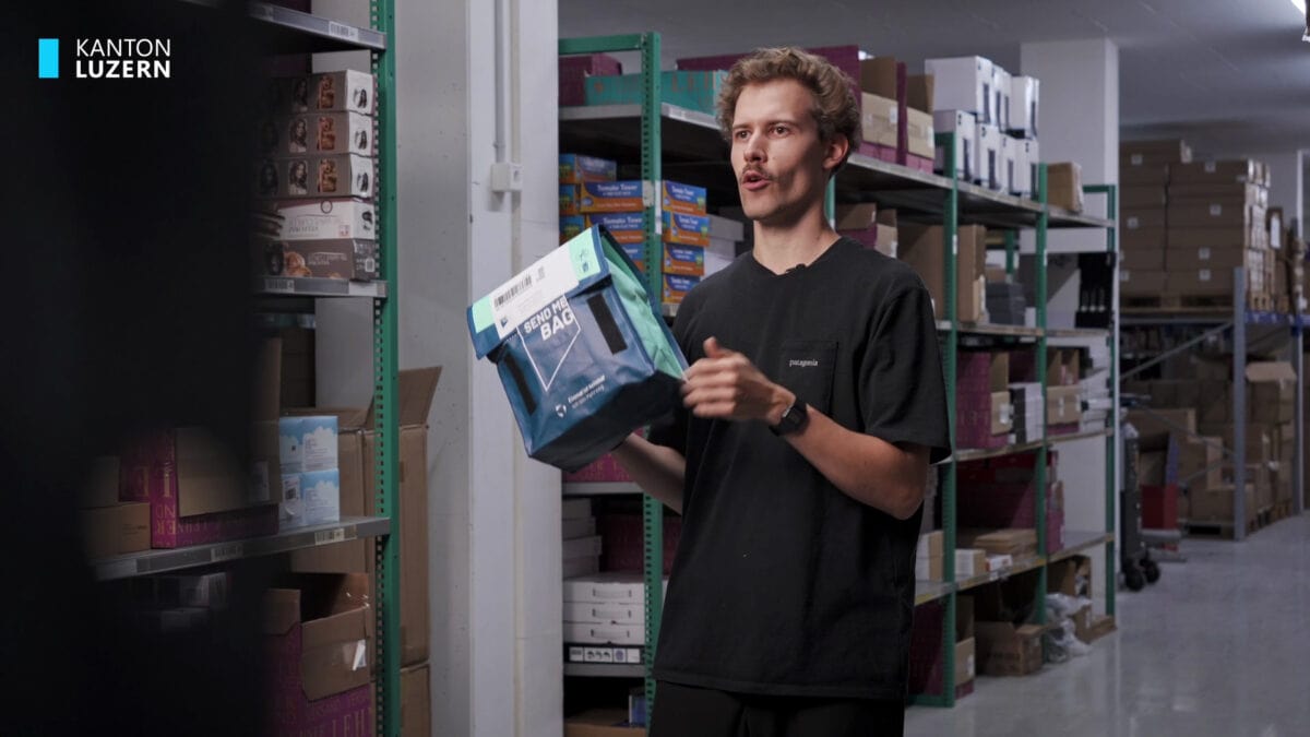 mann mit einer versandbox in einem lager voller regale
