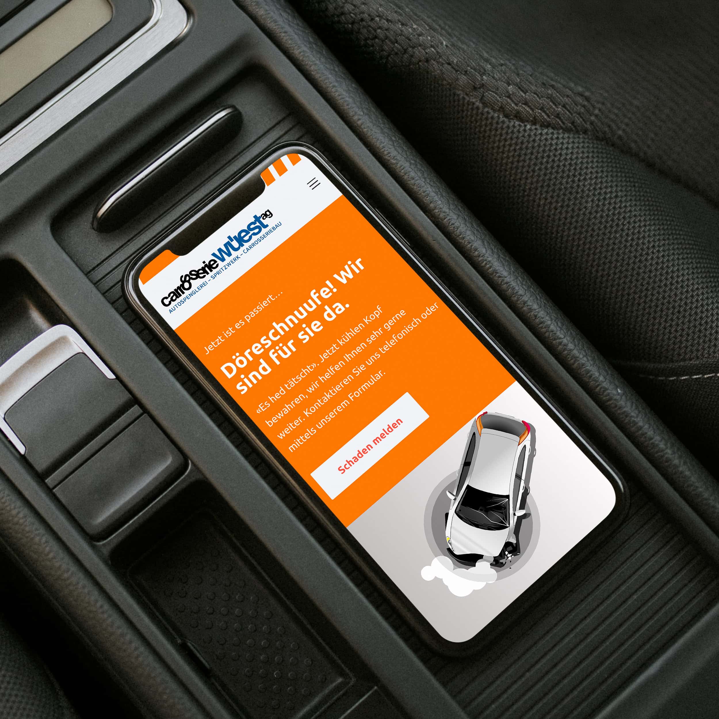 smartphone in der mittelkonsole mit der online-schadenmeldung