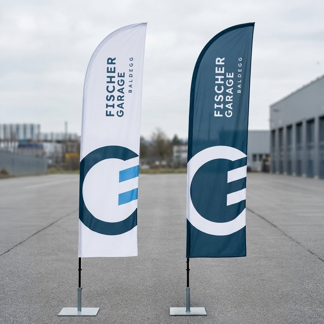 zwei beachflags der fischer garage baldegg in weiss und dunkelblau