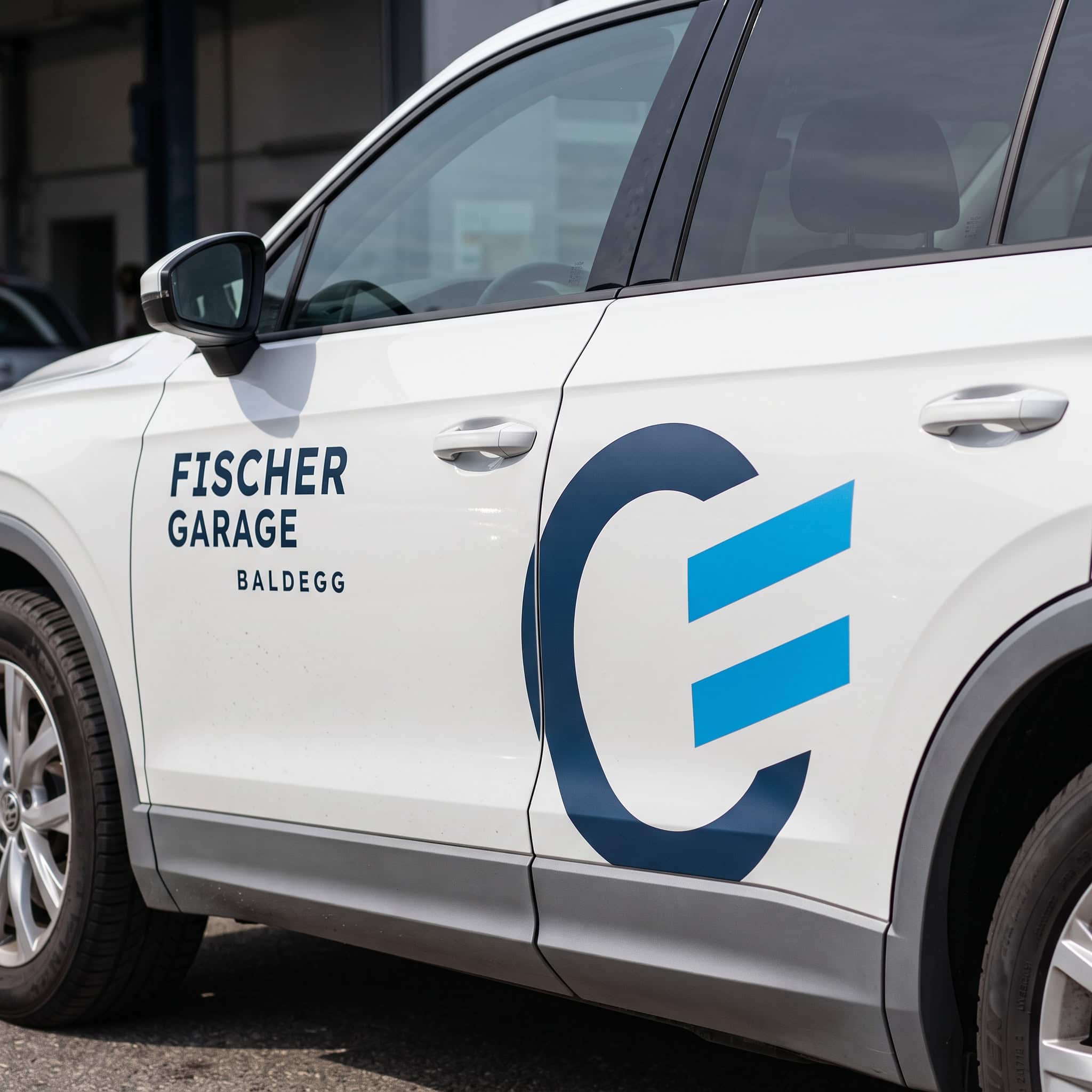 weisses auto mit beschriftung der fischer garage baldegg