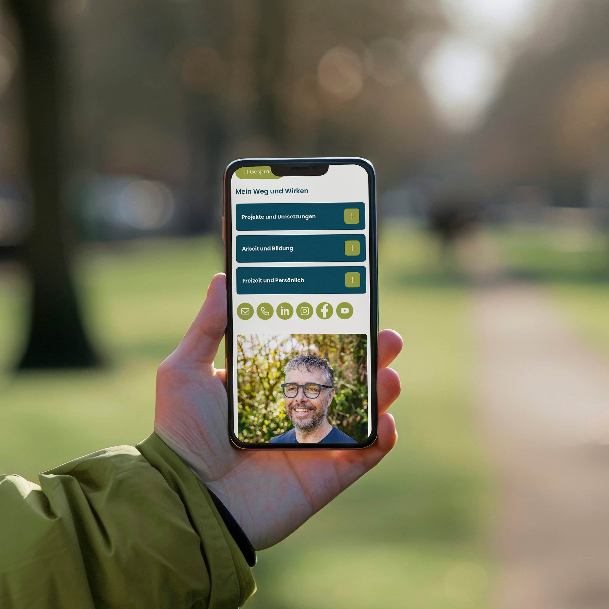 hand hält ein smartphone mit der hugge-website im park