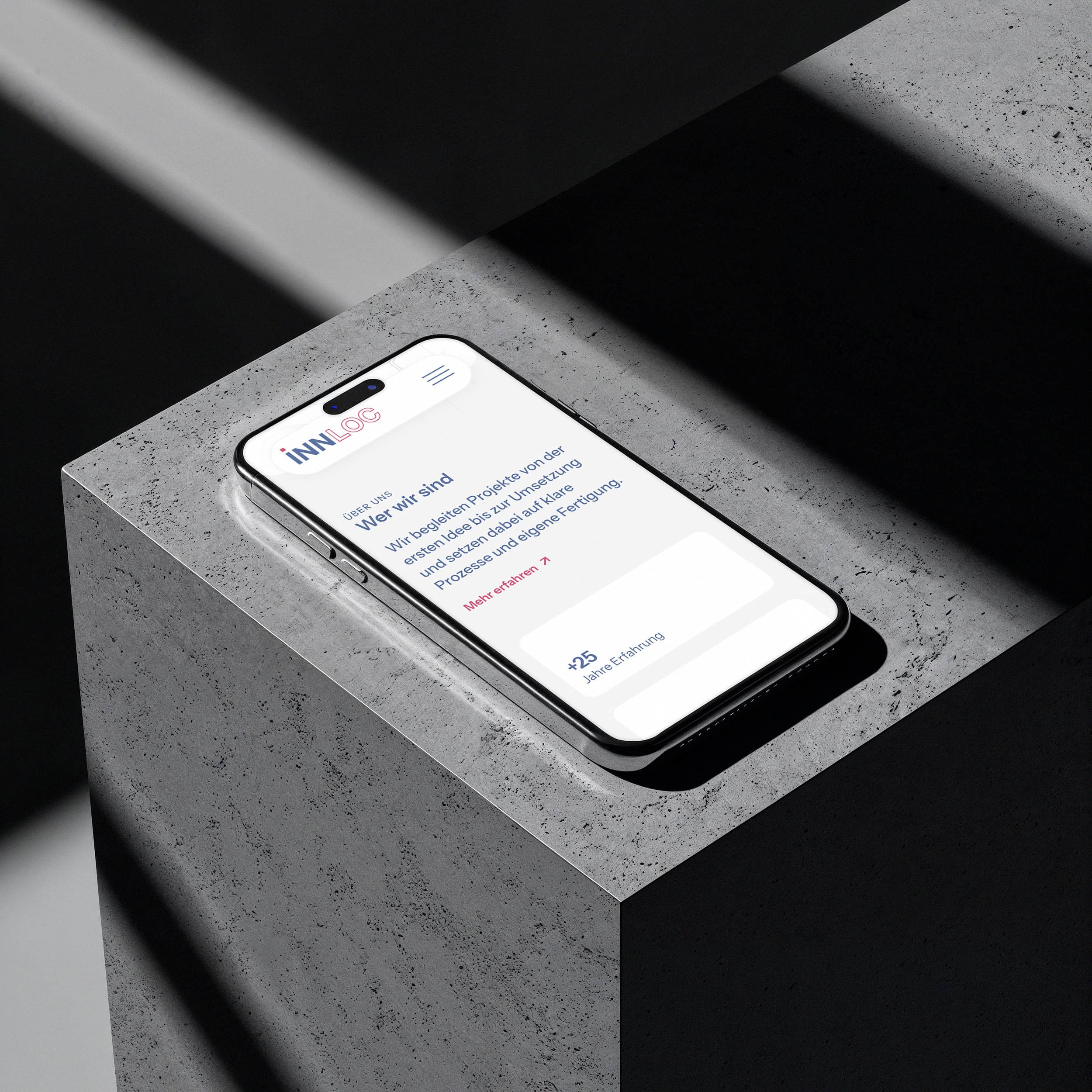 smartphone mit der innloc-website auf einem betonblock