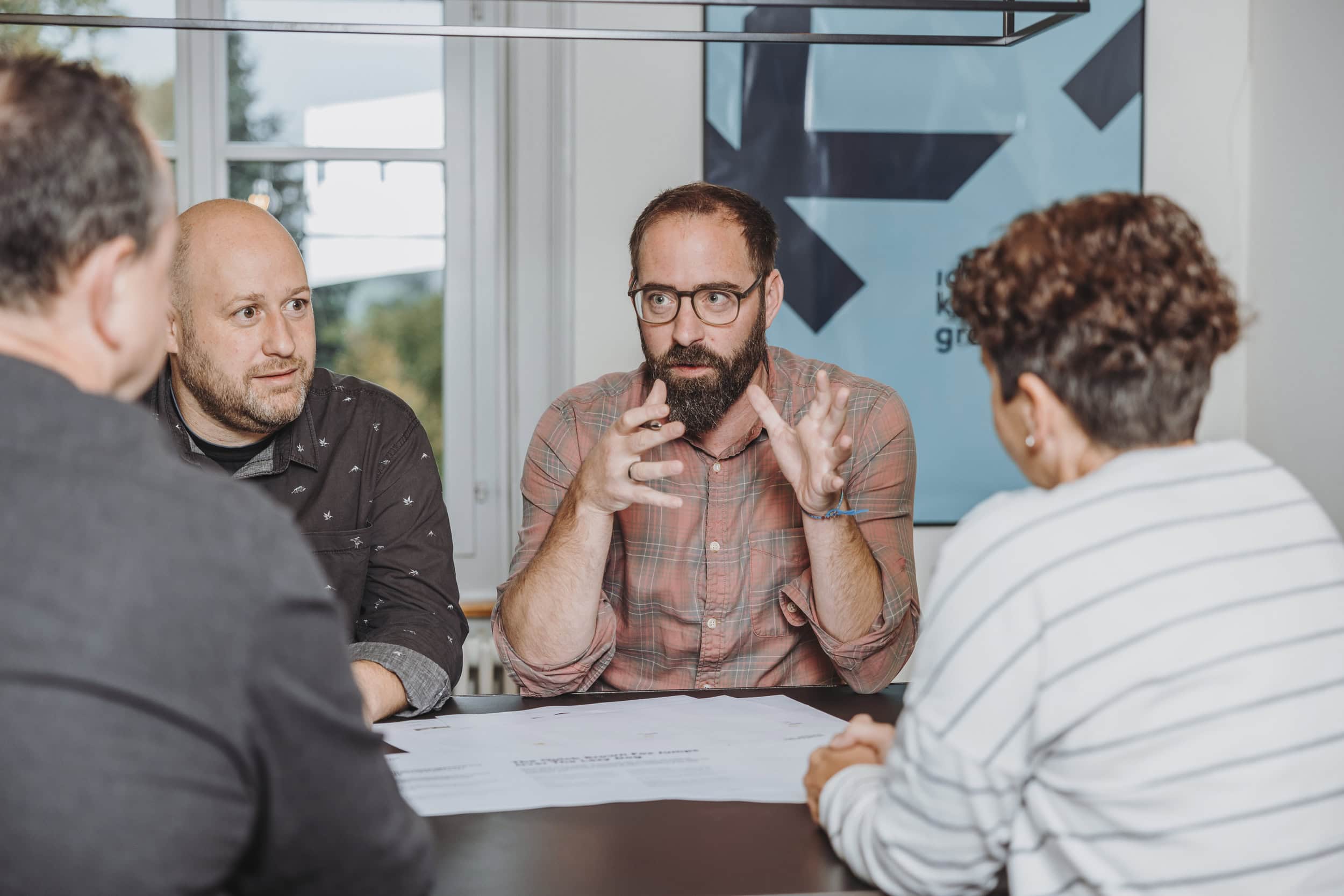 das team von konkret_ bespricht entwürfe am besprechungstisch