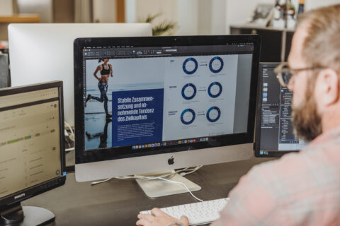grafiker arbeitet am bildschirm an einem broschürenlayout